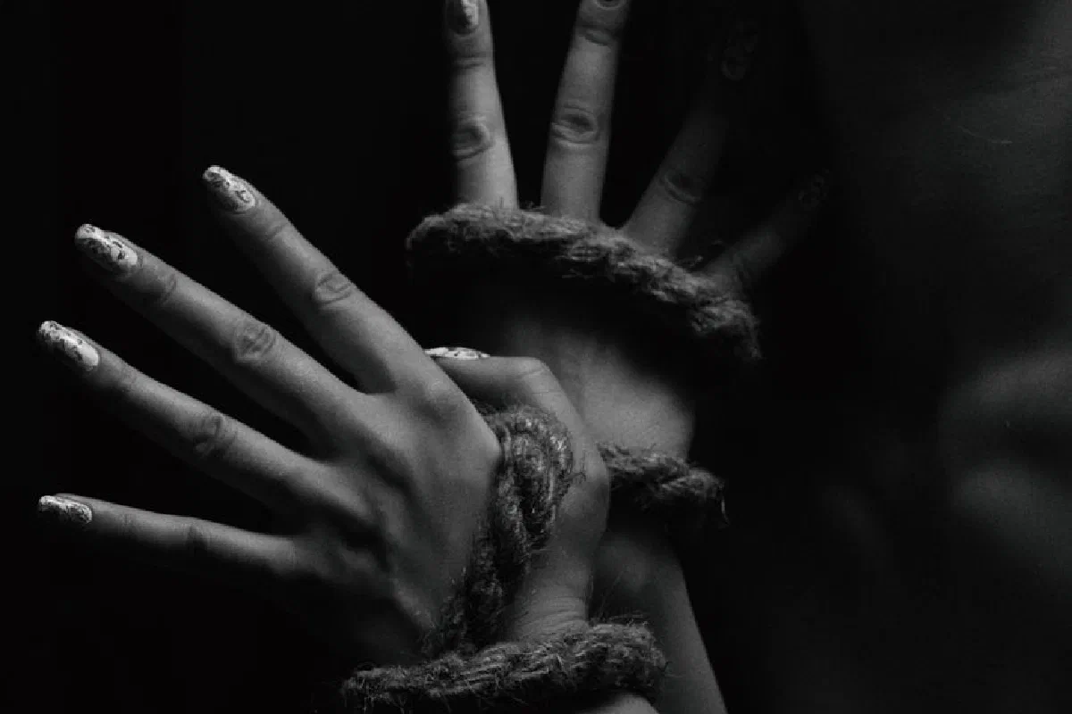 A close-up black and white photo depicting hands creatively bound with rope.