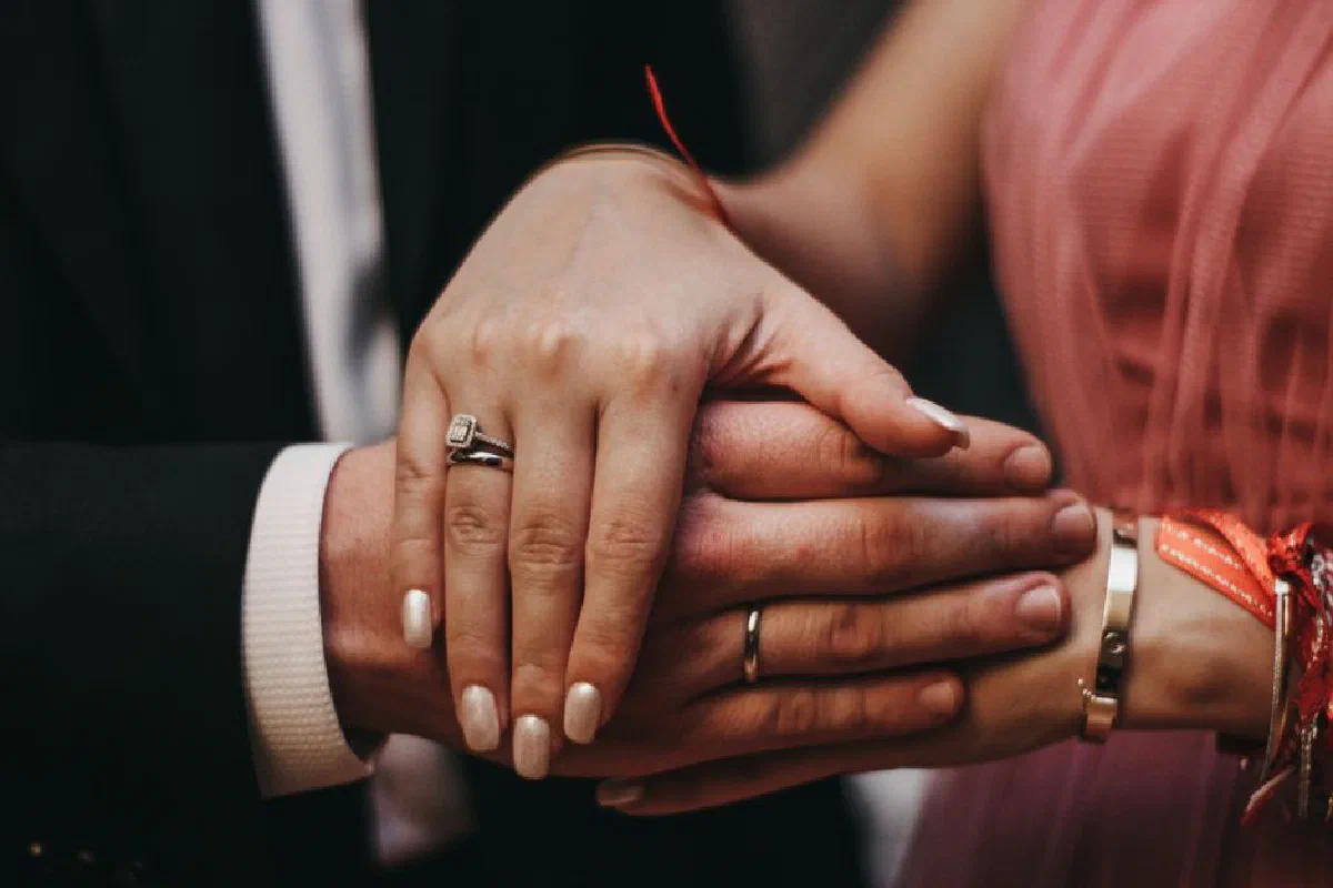 Close-up of a couple's hands with engagement rings, symbolizing love and commitment.