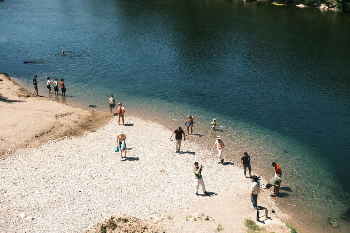 People enjoying a sunny day by the river in Podgorica, Montenegro. Perfect for outdoor leisure.