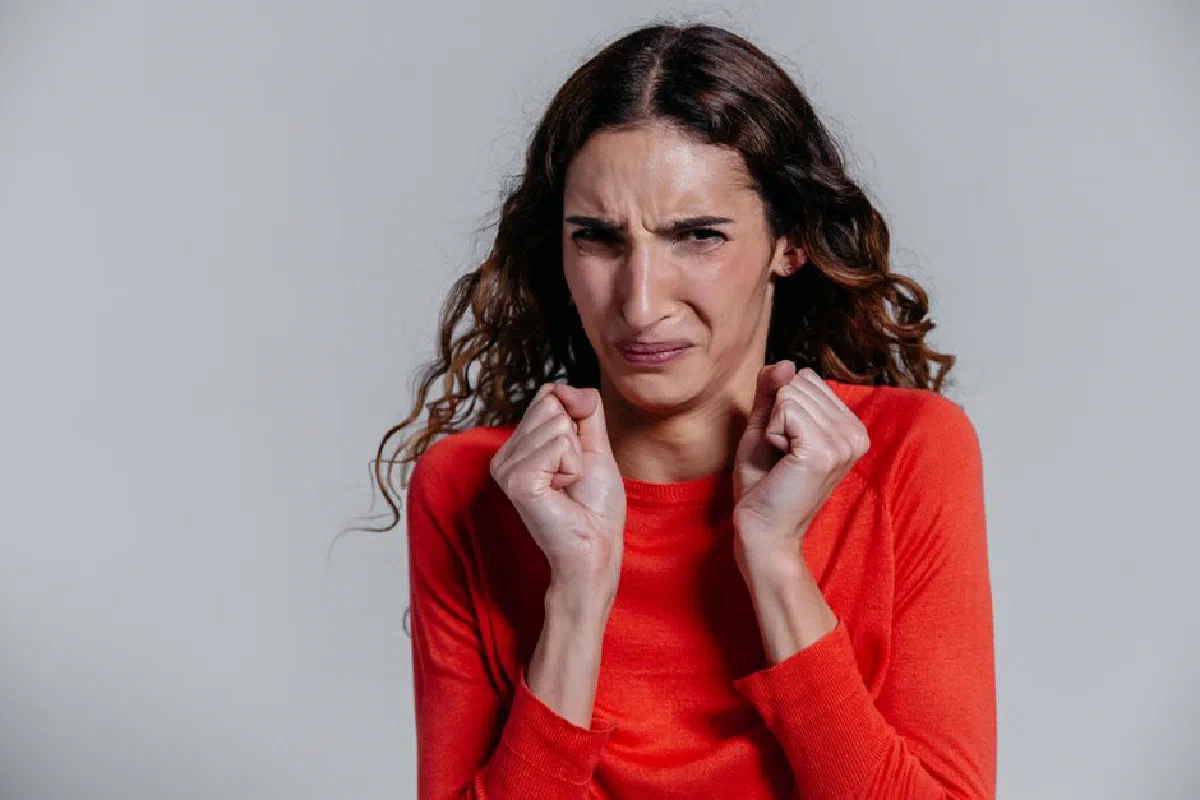 A woman displaying a disgusted facial expression indoors.