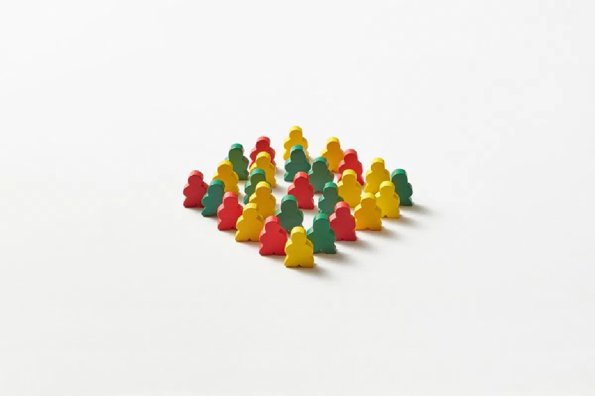 Cluster of multicolored game pawns arranged on a plain white background.