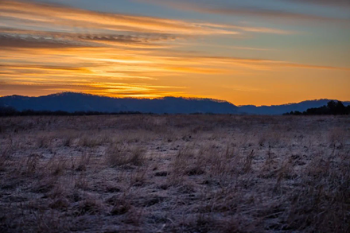 A breathtaking sunset over the frosty fields with hills in the background in West Newton, Minnesota.