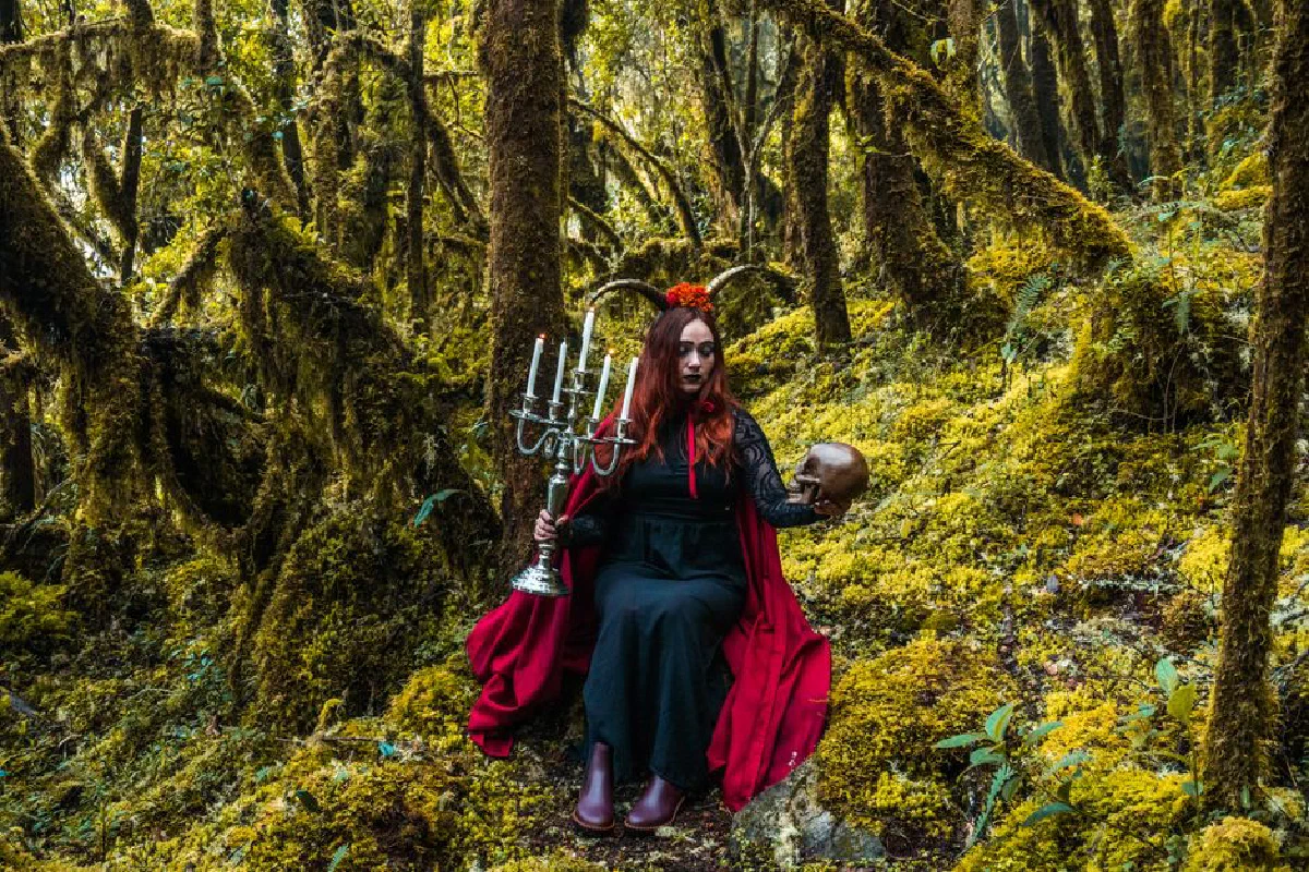 A mystical forest witch holding a candelabra and skull in Choachí, Colombia.
