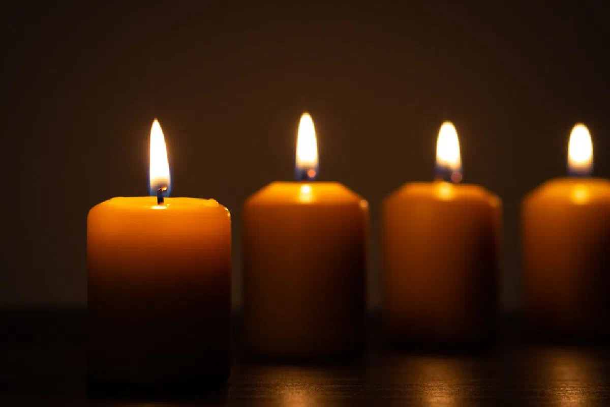 Four burning candles creating a warm and tranquil ambiance with a soft glow.