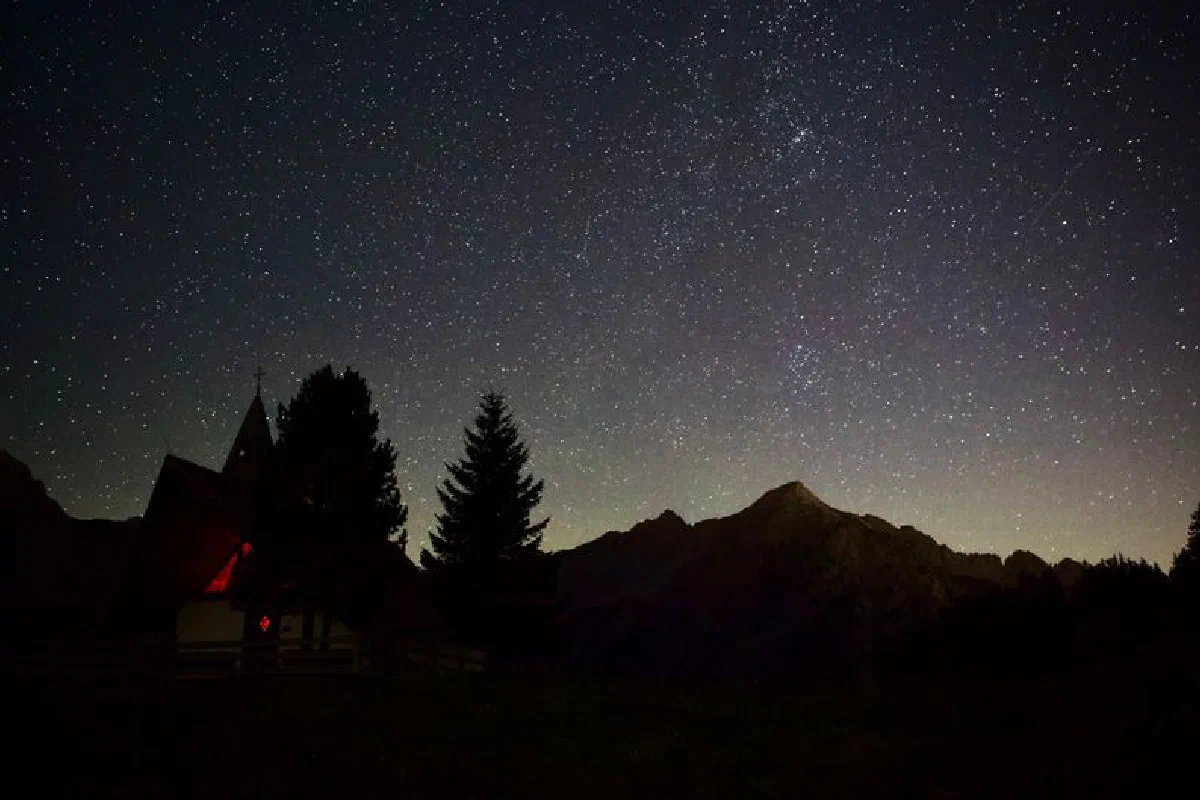 Captivating view of a starry night sky above the mountains in Gnadenwald, Tirol, Austria.