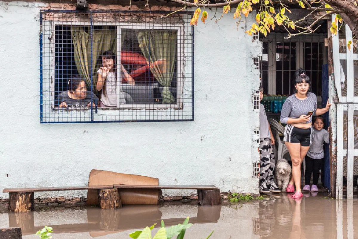 Families coping with flooding in Buenos Aires, reflecting climate impact.