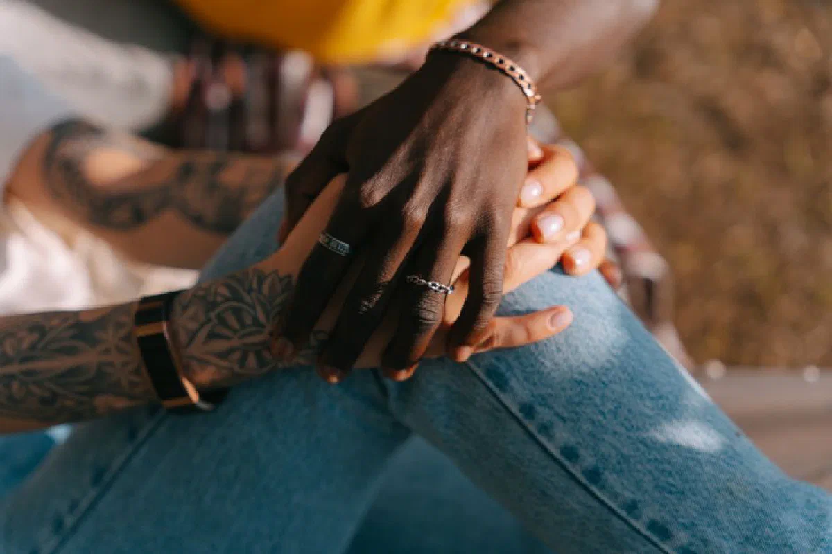 A close-up shot of an interracial couple holding hands showcasing love and unity.