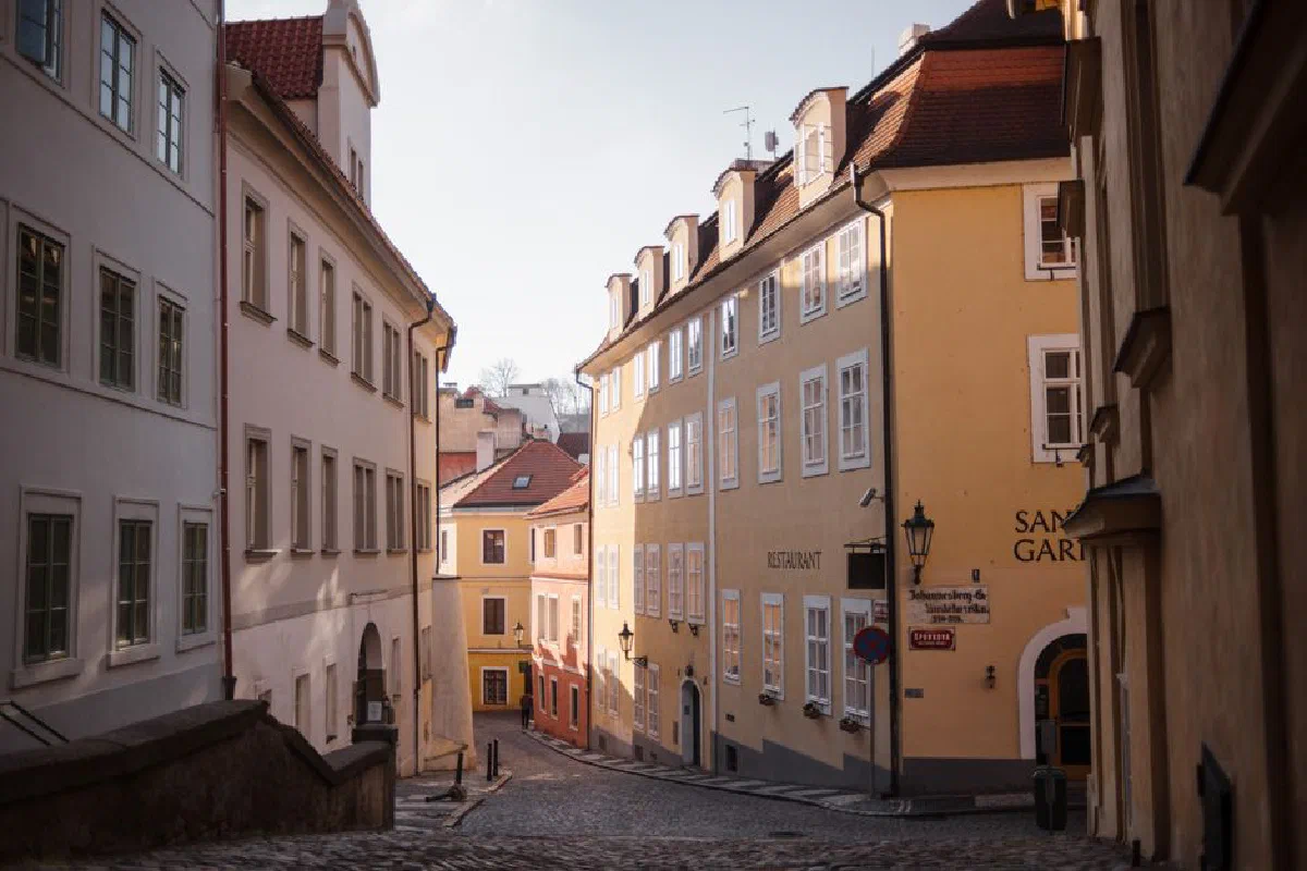 Narrow pedestrian cobblestone street between apartment buildings in residential town district on sunny day