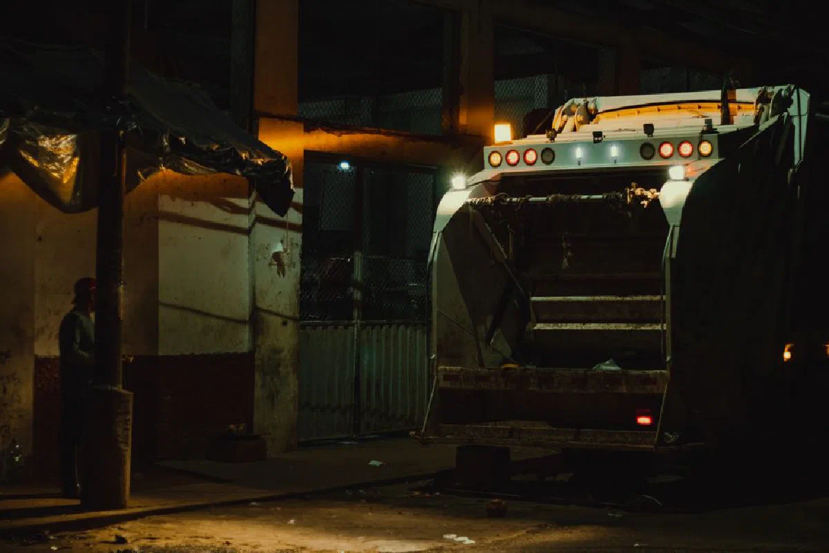Garbage truck at night under city lights in Yurimaguas, Peru.