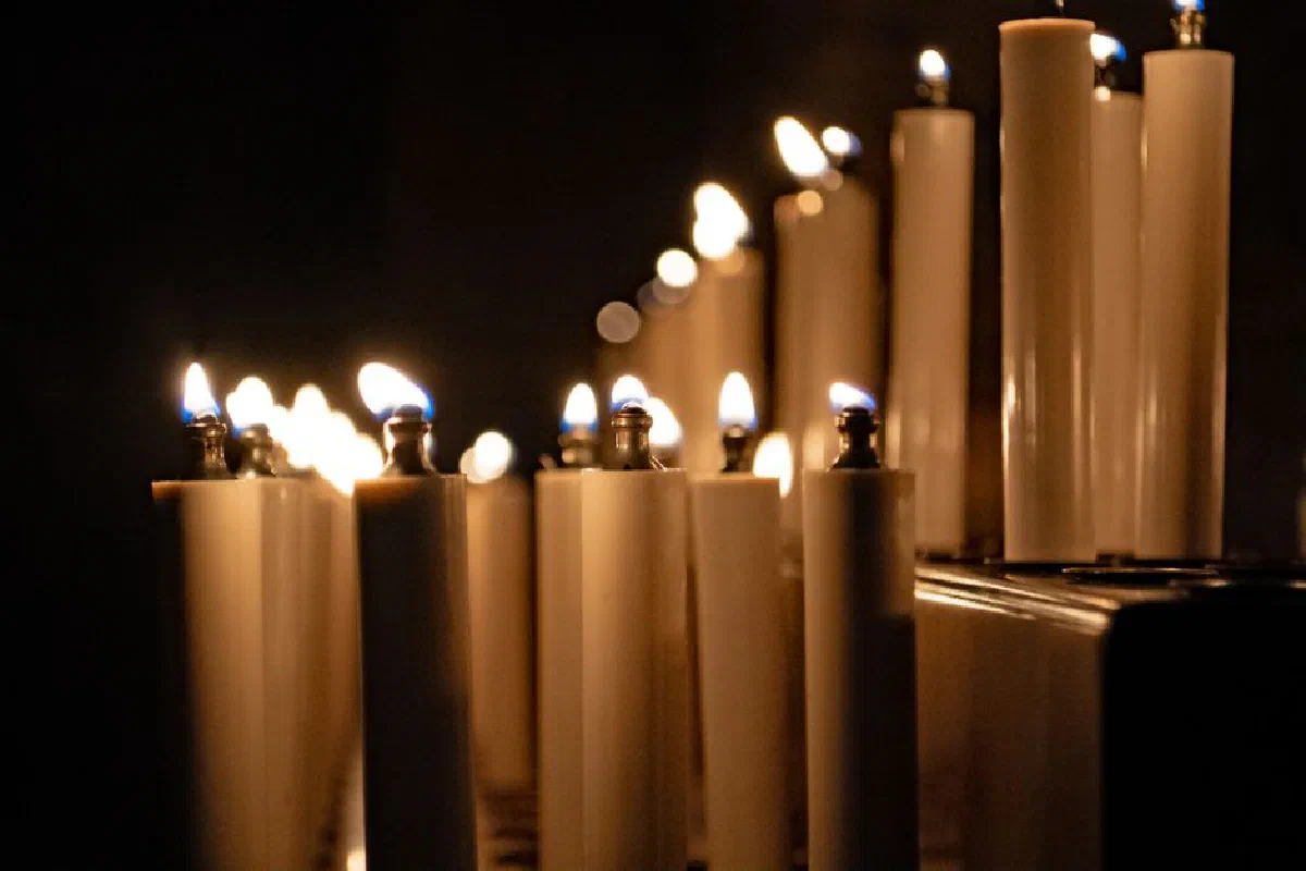 A serene display of burning candles inside a dimly lit cathedral in Regensburg, Germany.