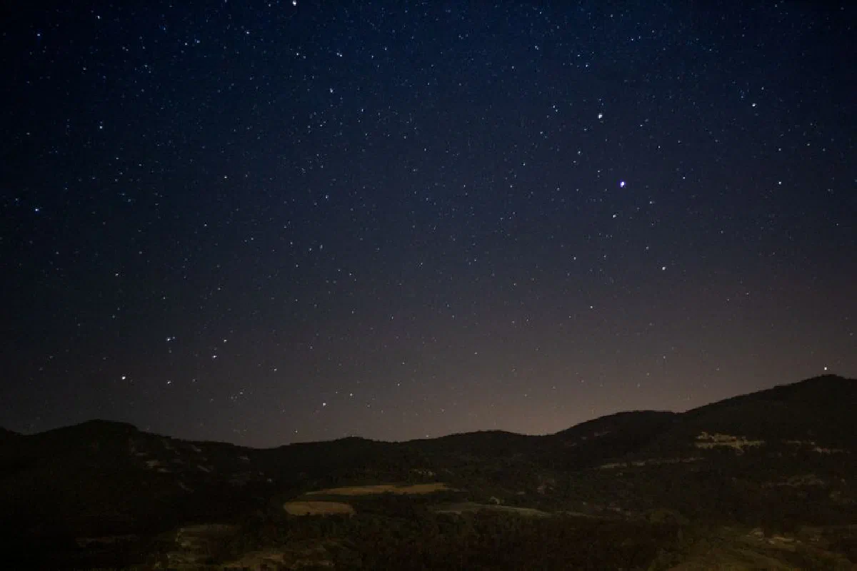Beautiful starry night sky over a calm mountain landscape, showcasing the wonders of astronomy and nature.