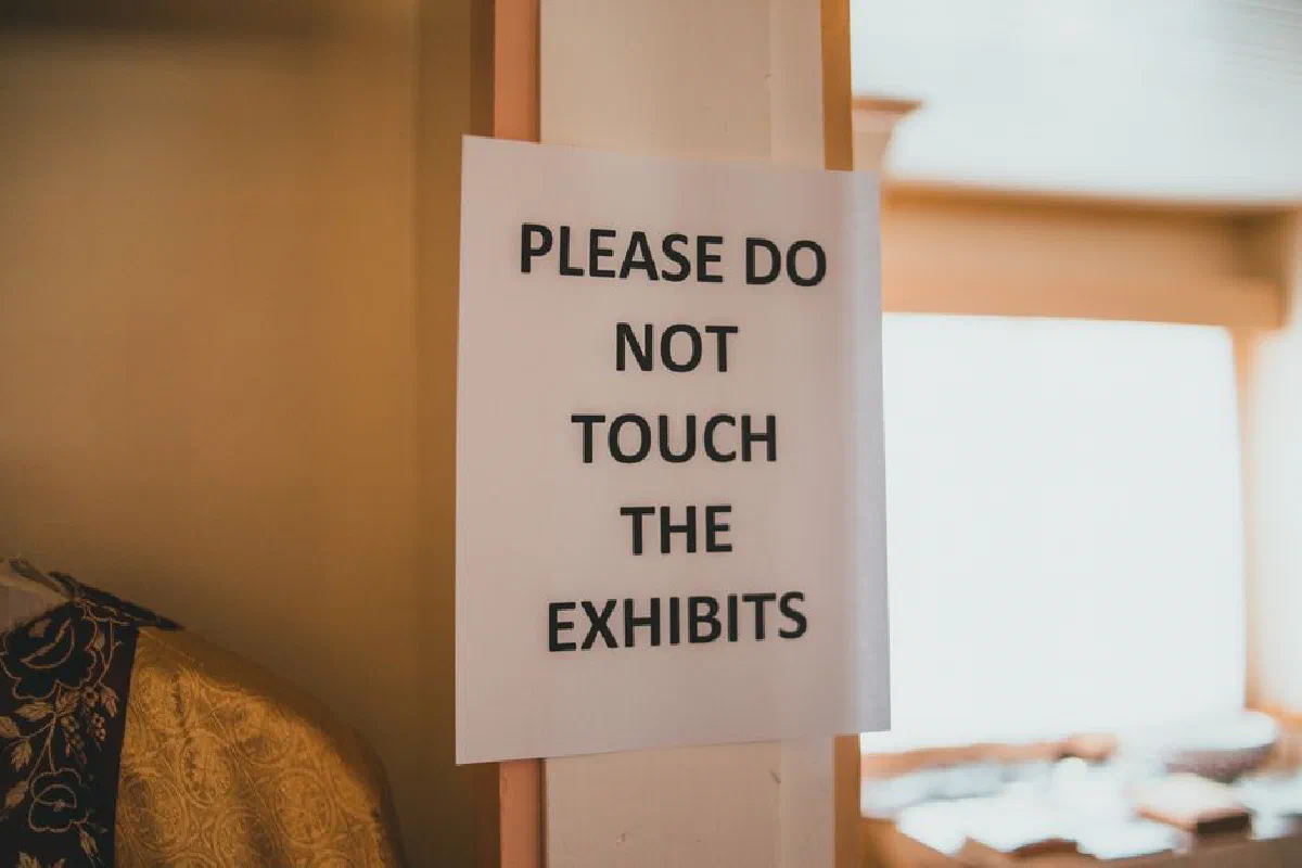 A warning sign in a museum advising visitors not to touch exhibits.