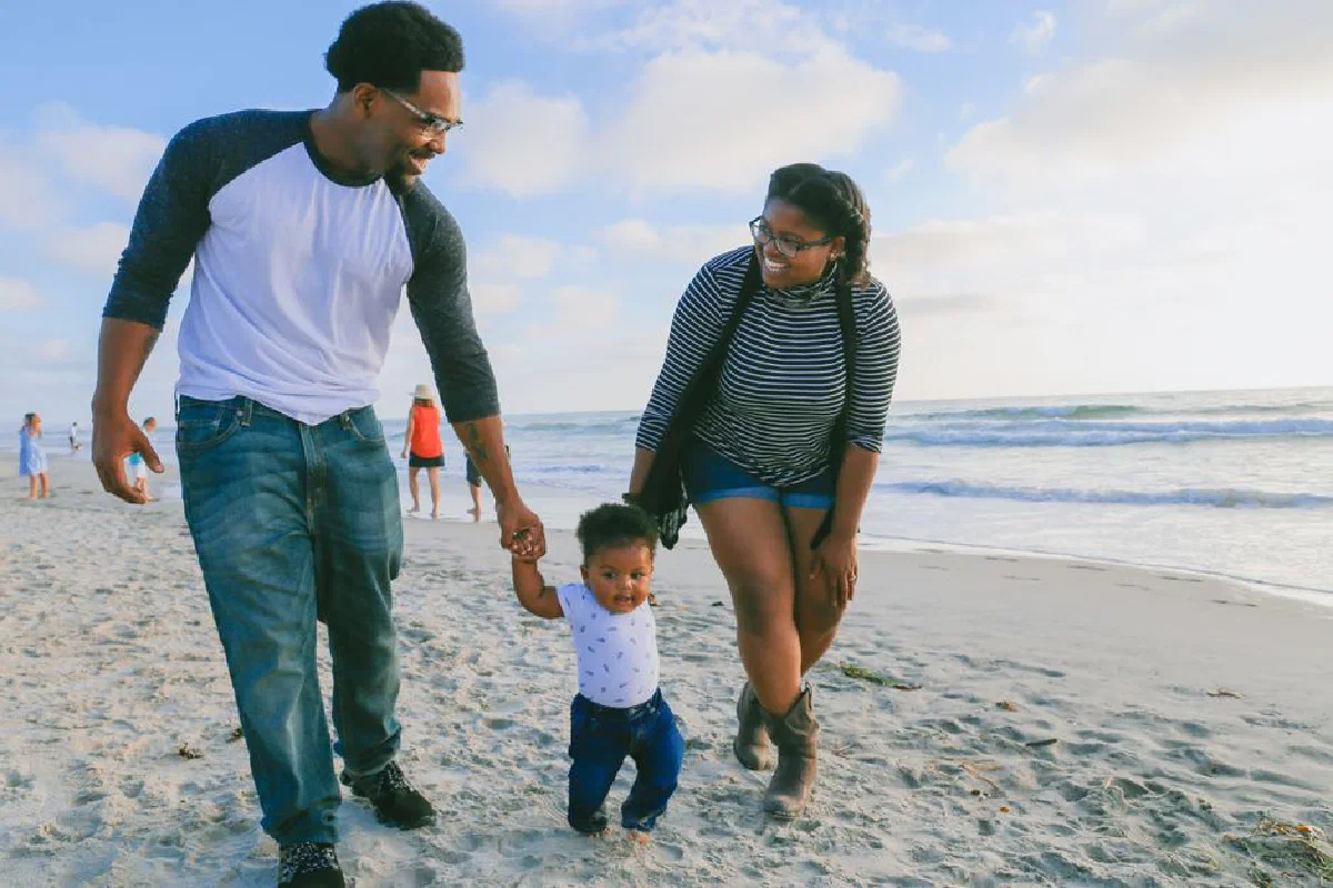 A joyful family enjoys a sunny day walking on Del Mar Beach, CA.