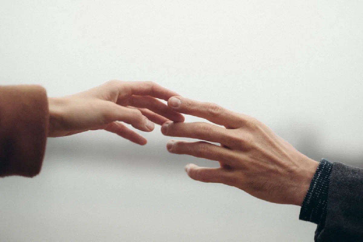 Two hands reaching out, symbolizing connection and intimacy.