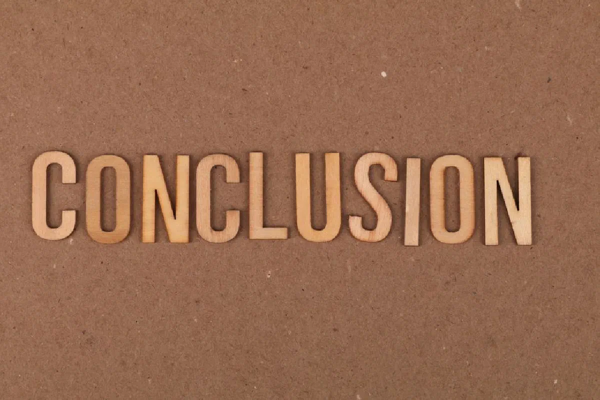 Wooden letters arranged to spell 'Conclusion' on a brown cardboard background.