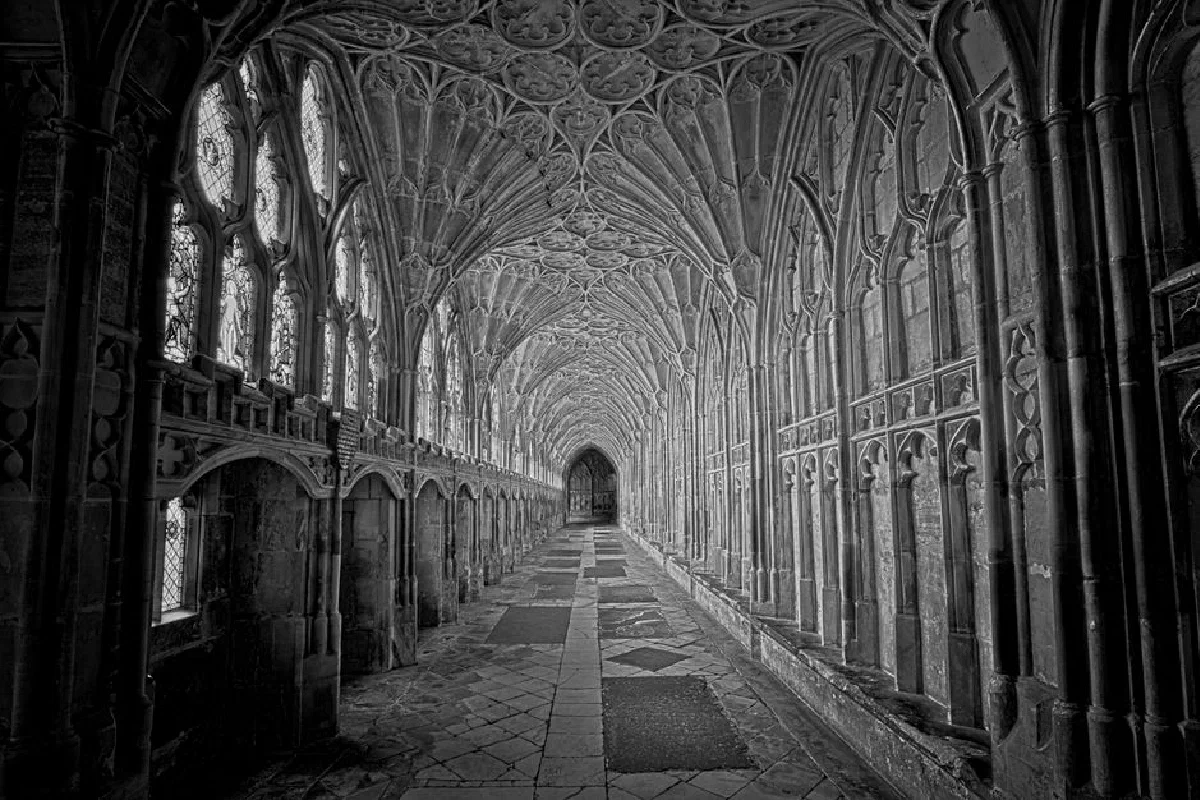 Stunning black and white view of a Gothic cloister in Gloucester Cathedral, England.