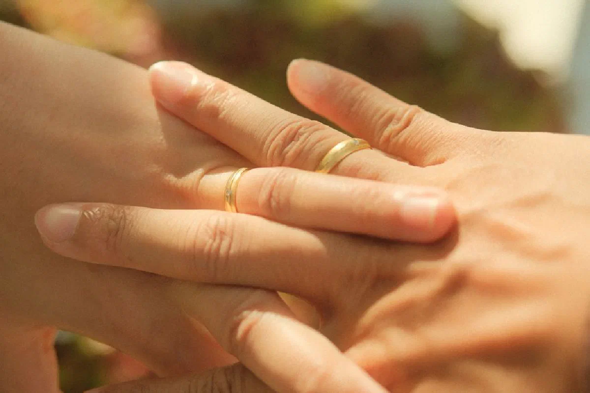 A tender close-up of two hands with wedding rings showcasing love and unity.