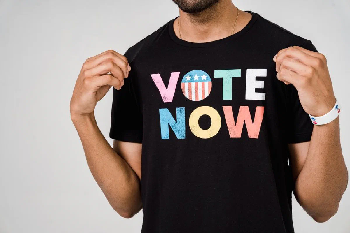 Close-up of individual wearing a 'Vote Now' t-shirt, emphasizing civic engagement.