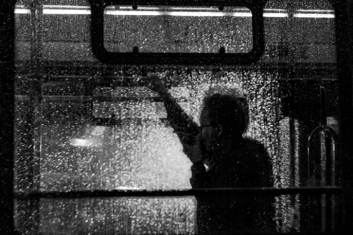 Silhouette of a person on a bus in Buenos Aires during rain.