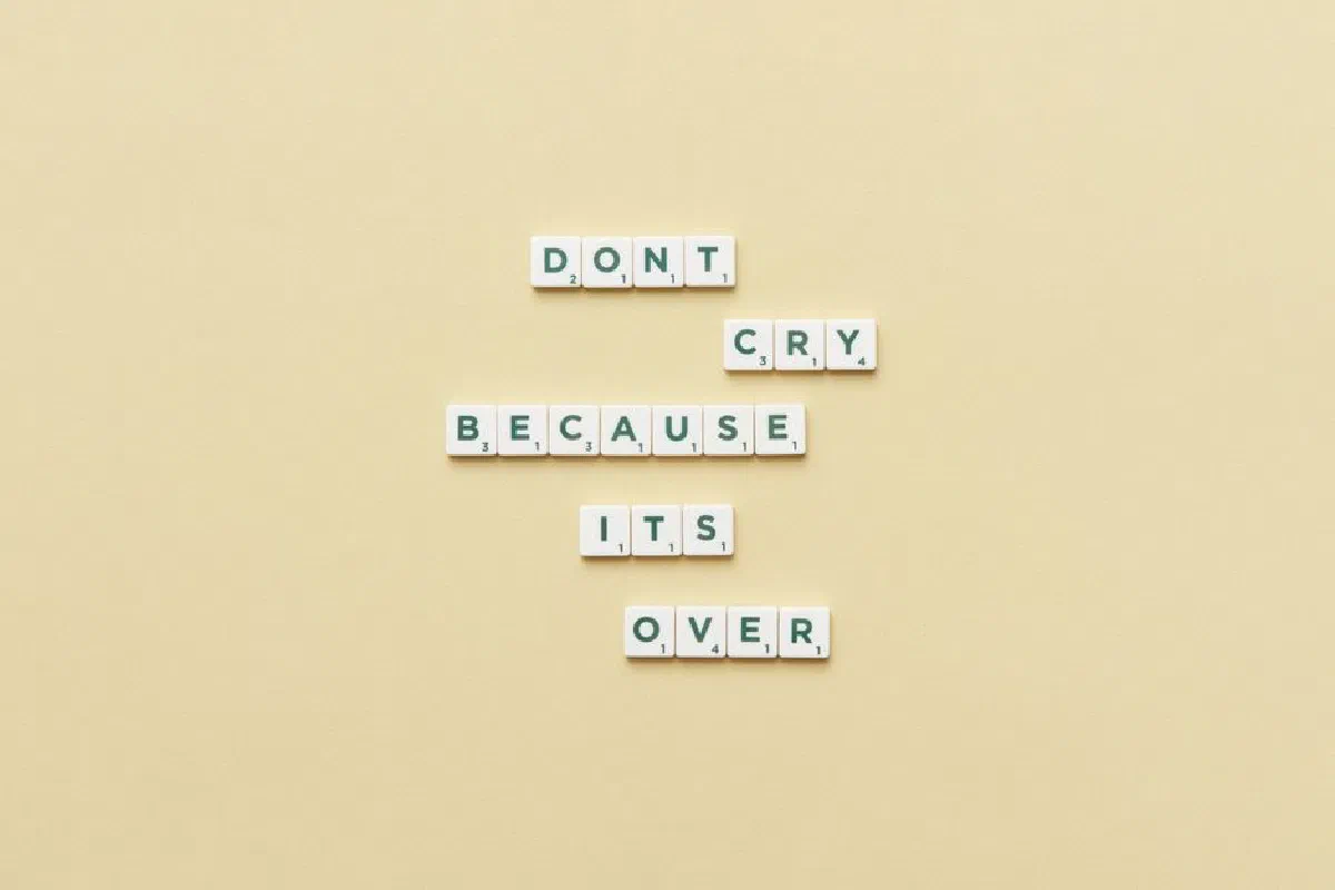 Scrabble tiles forming an inspirational message on a soft yellow background, encouraging reflection.