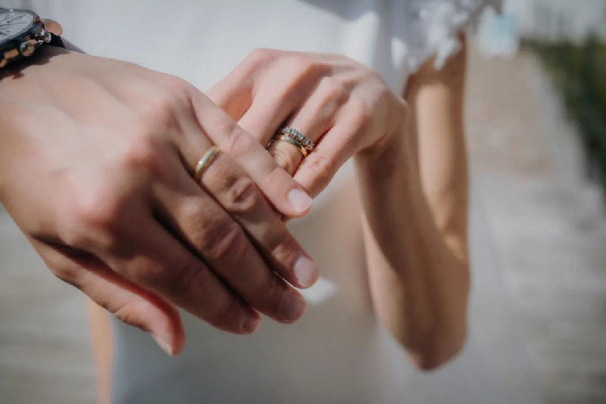 Intimate close-up of hands exchanging wedding rings symbolizing love and commitment.