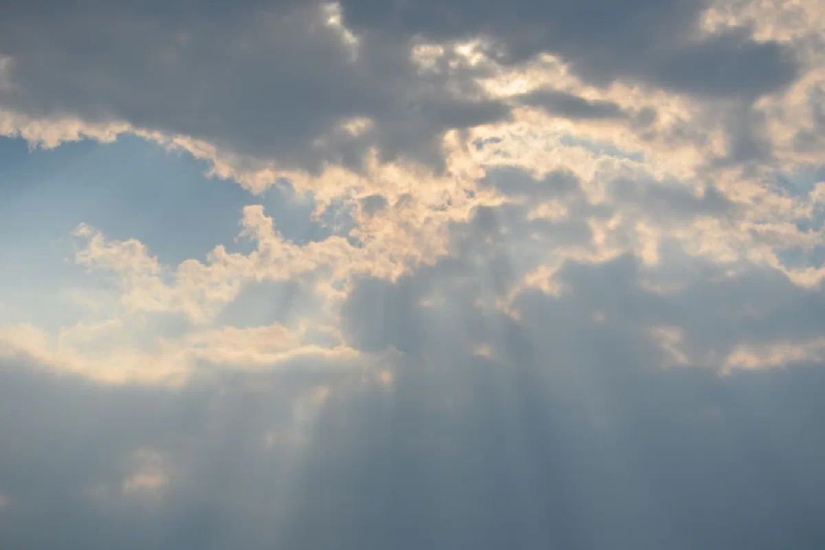 Beautiful sun rays breaking through clouds creating an ethereal sky at dusk.