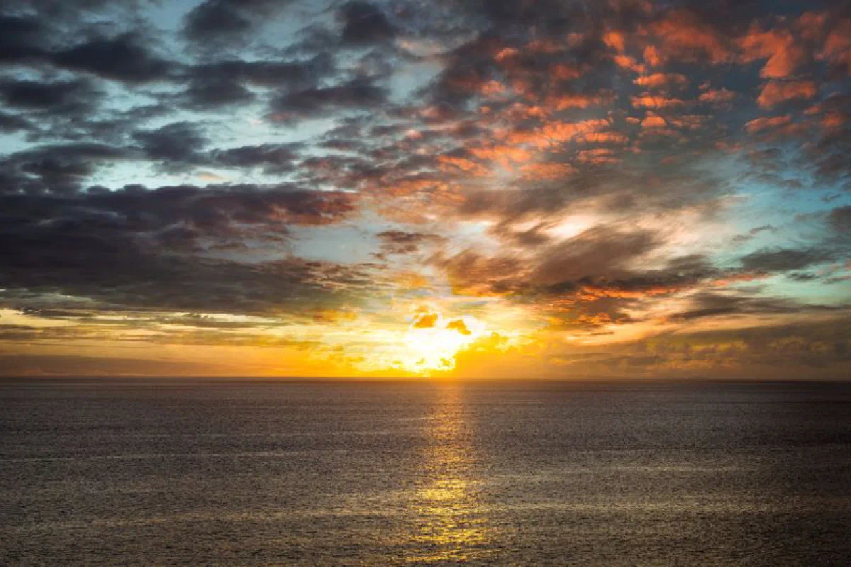 A breathtaking sunset over the ocean with dramatic clouds and vivid colors.