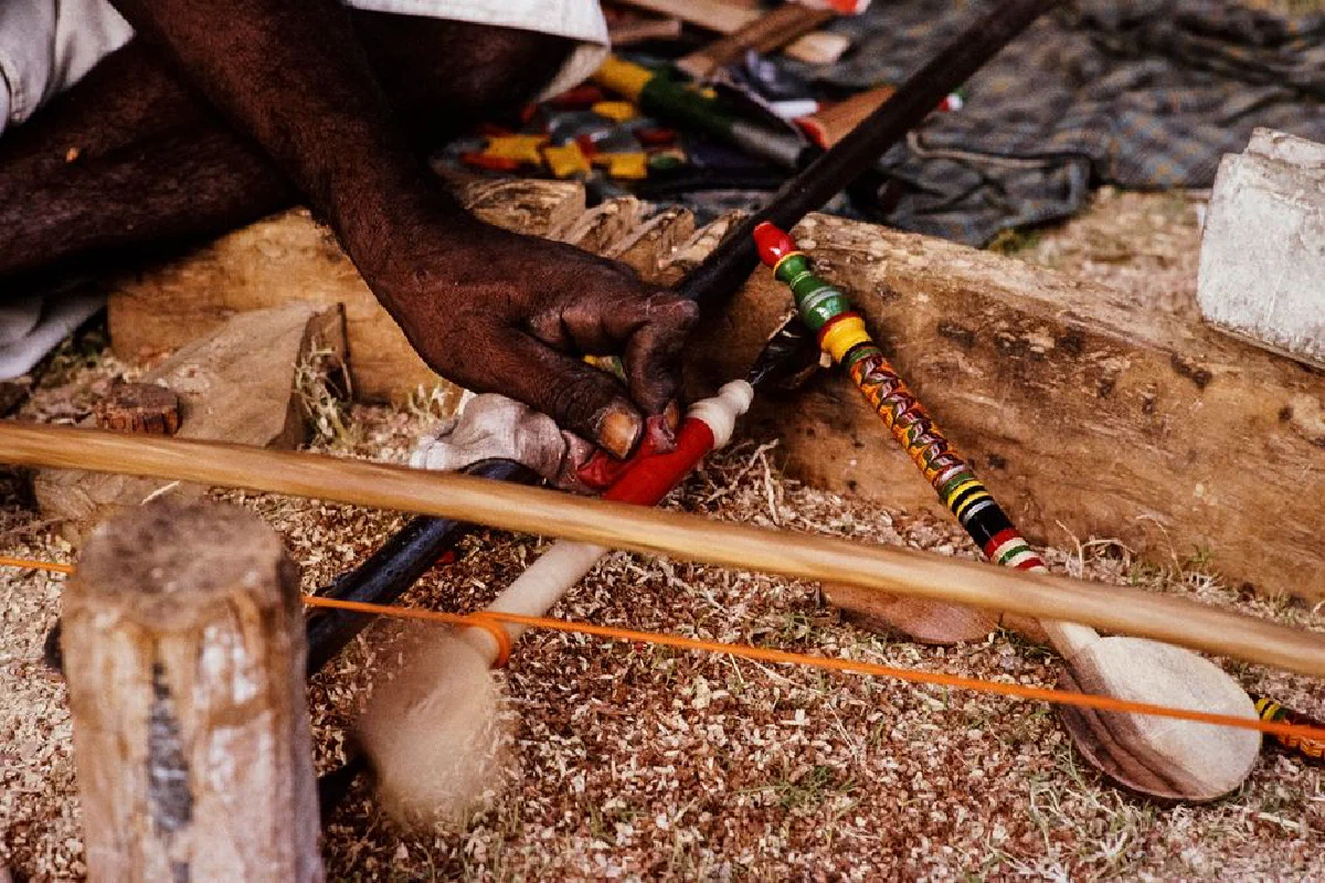 Close-up of an Indian craftsman working with colorful traditional tools, showcasing artisanal skill.