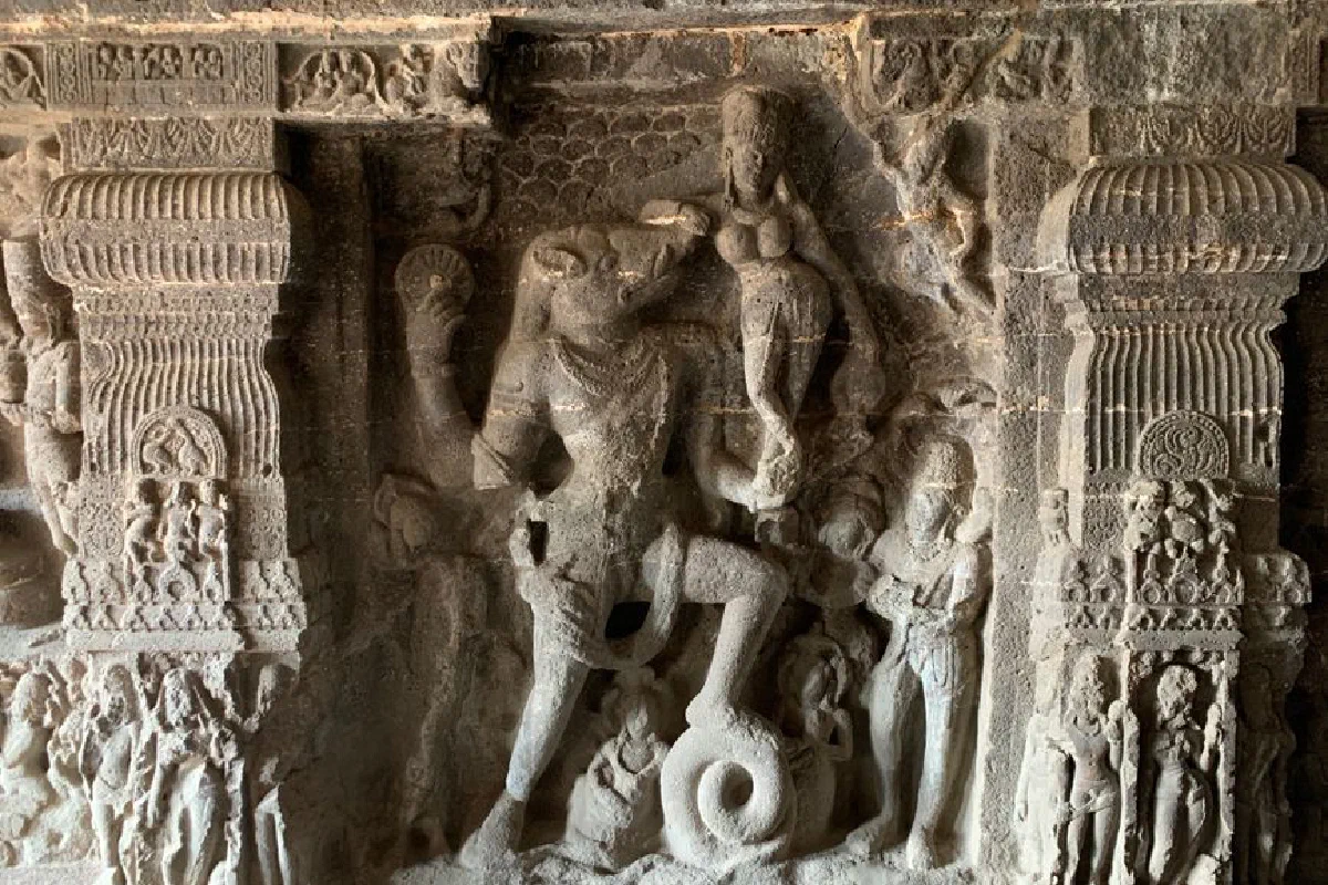 Detailed stone carvings of ancient Hindu deities in a cave temple with intricate craftsmanship.