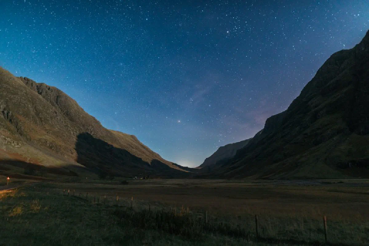 A breathtaking view of a starry night over a mountain valley, capturing the serene beauty of nature.