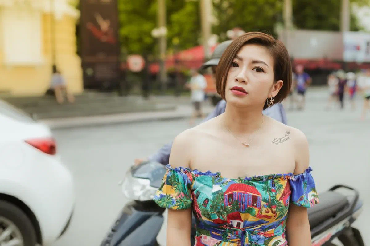 Portrait of a stylish woman in colorful attire on a city street.