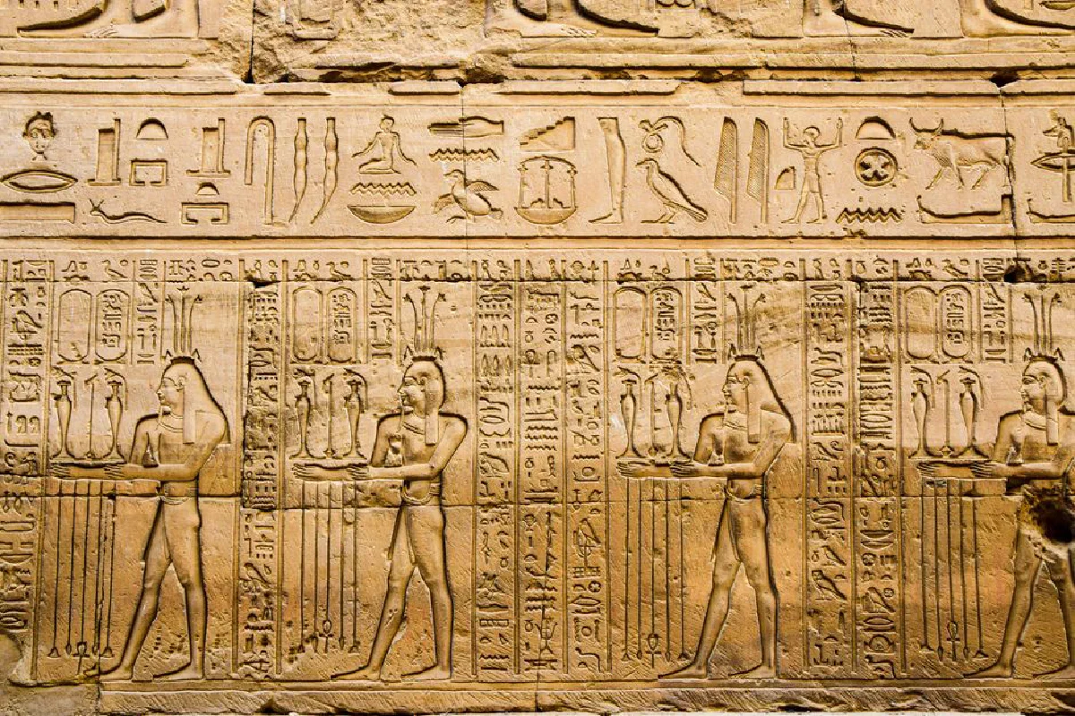 Detailed hieroglyphics and carvings on a wall in Luxor, Egypt, showcasing ancient history.