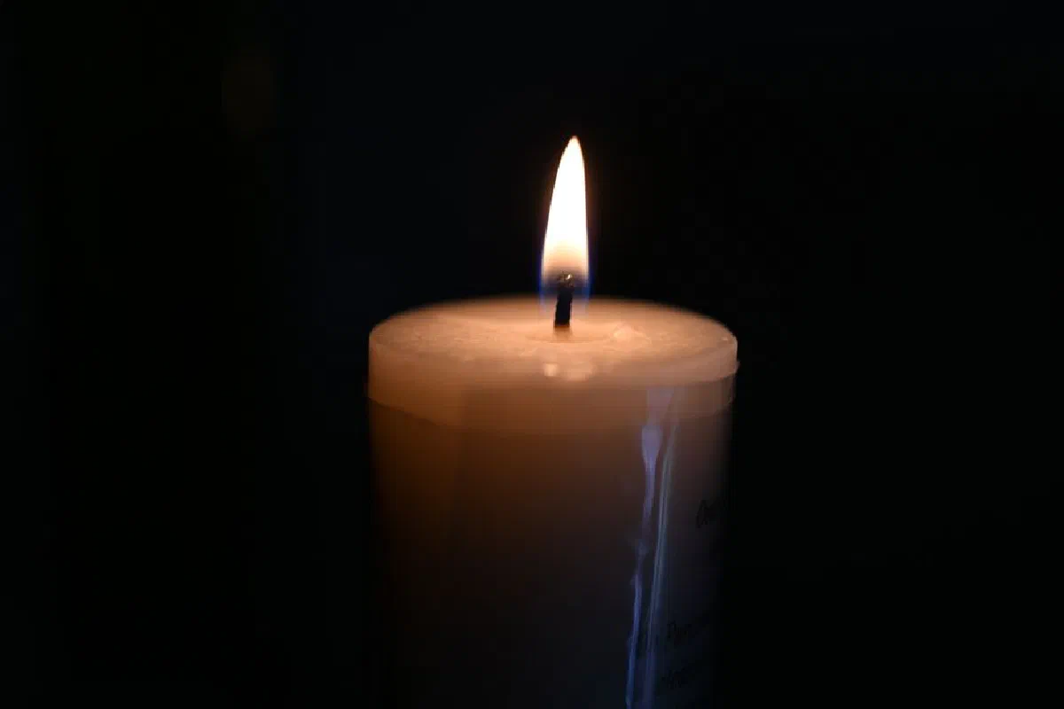 A serene close-up of a candle flame against a dark background, evoking calm and tranquility.