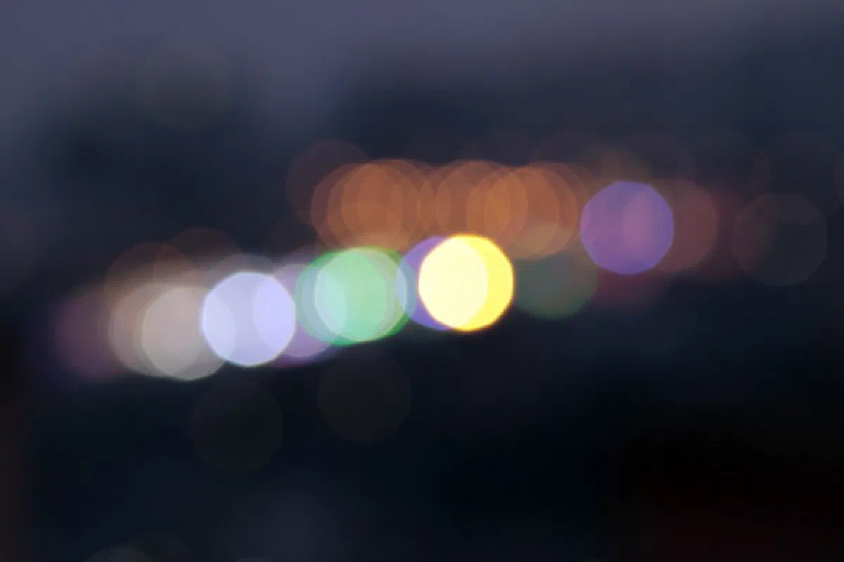 Abstract bokeh image with colorful blurred lights against a dark background.