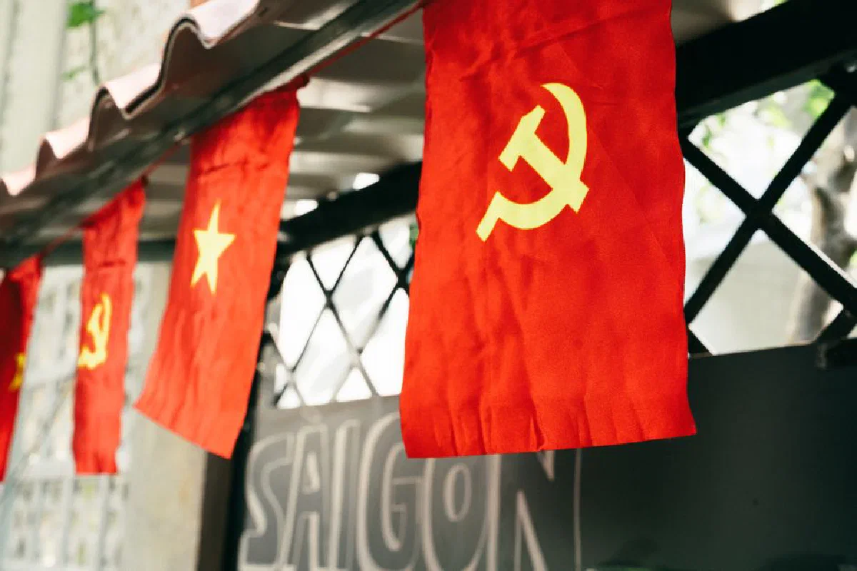 Vietnamese flag with hammer and sickle symbol displayed outdoors, representing communism in Saigon.