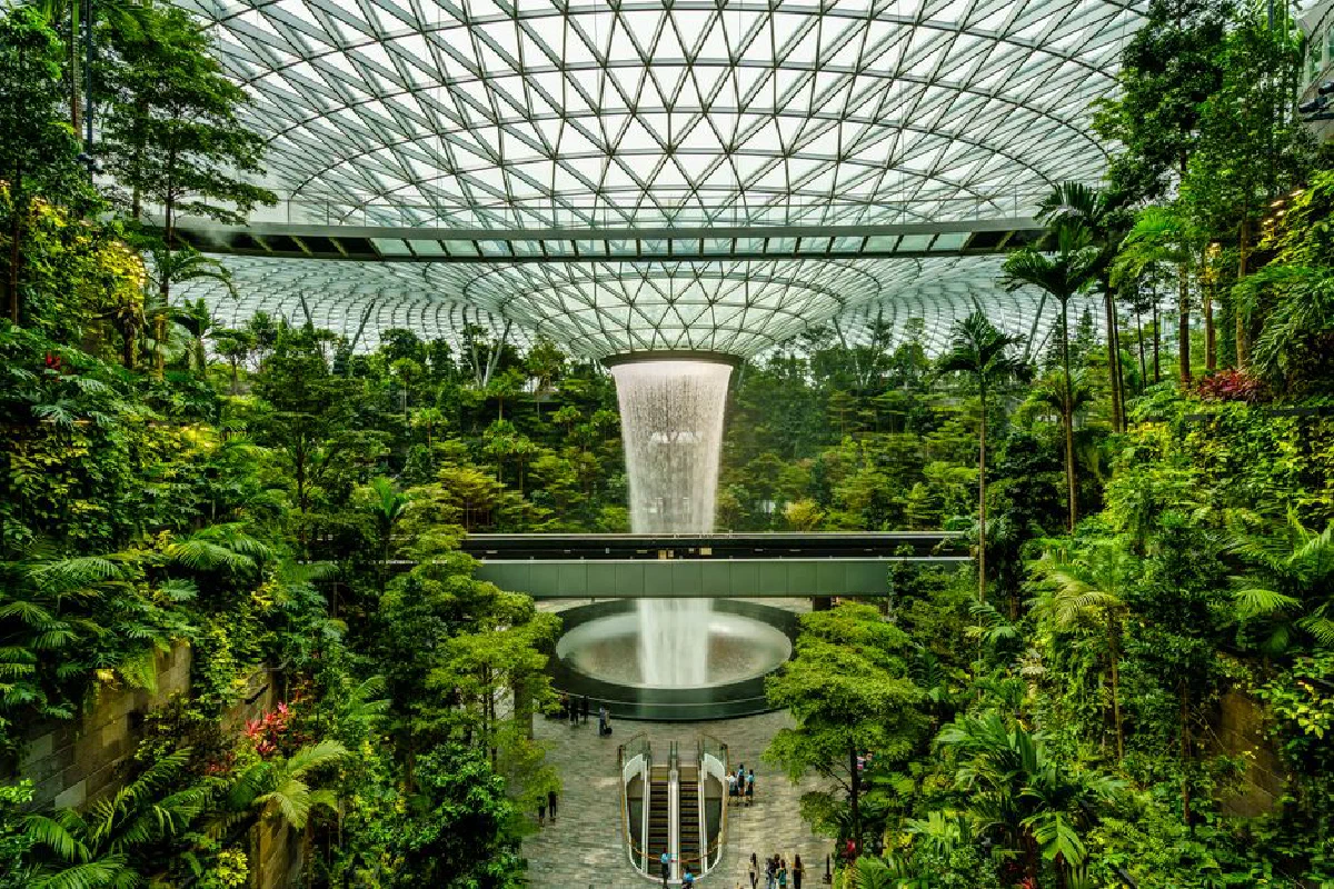 Explore the lush indoor garden with the iconic waterfall at Changi Airport, a blend of nature and modern architecture.