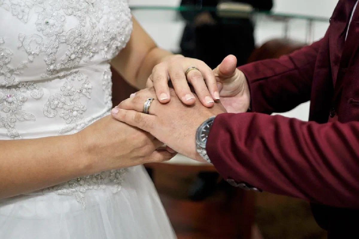 Close-up of bride and groom exchanging rings, symbolizing union and commitment during a wedding ceremony.