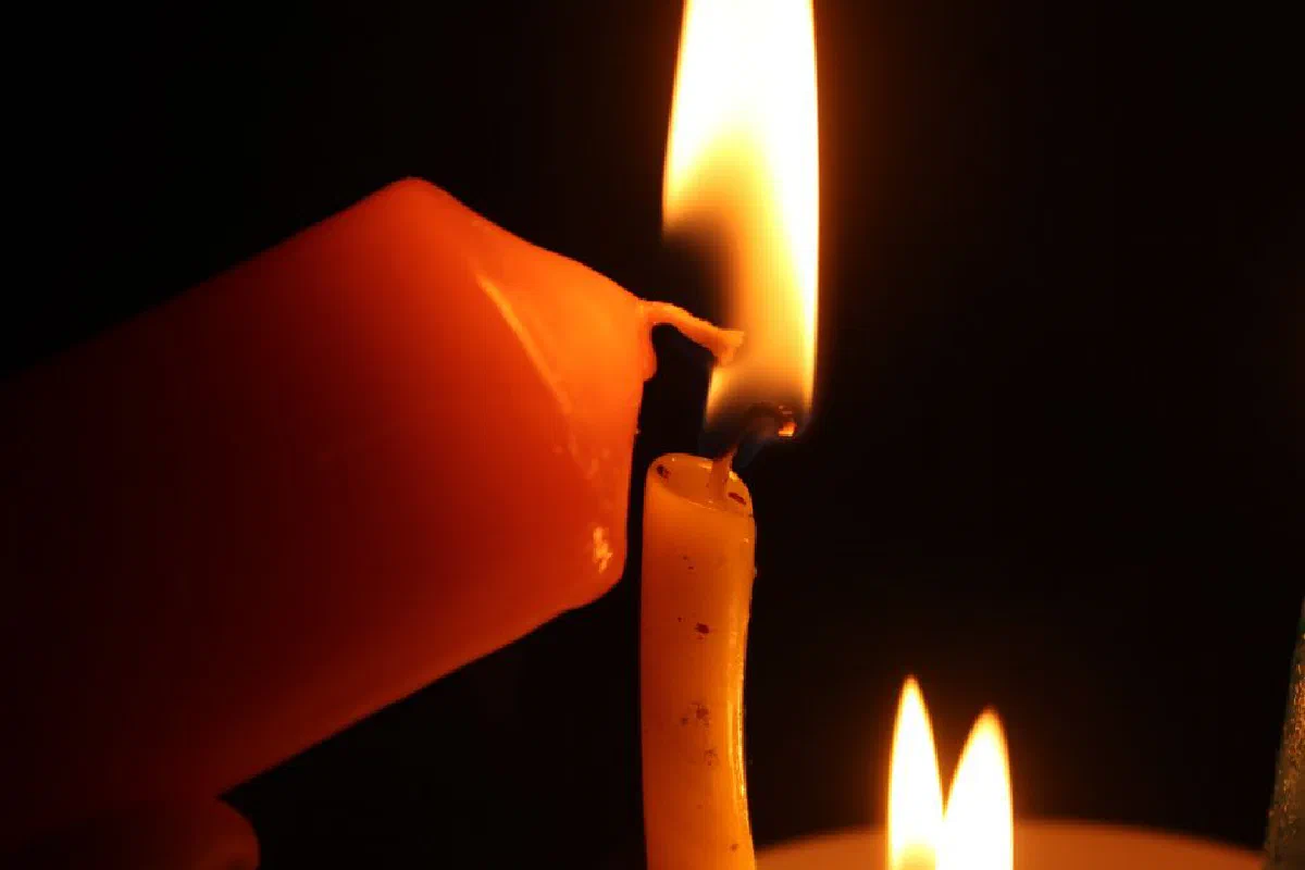 Mesmerizing close-up of two candles with flames in a dark setting, creating a serene atmosphere.