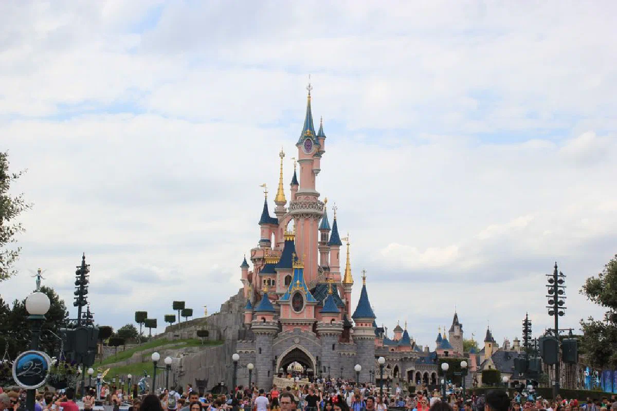 Scenic view of Sleeping Beauty Castle at Disneyland Paris with a bustling crowd.