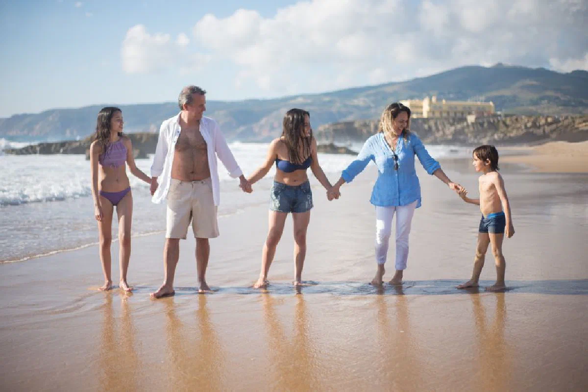 Family enjoying a sunny day at the beach in Portugal, bonding and having fun.