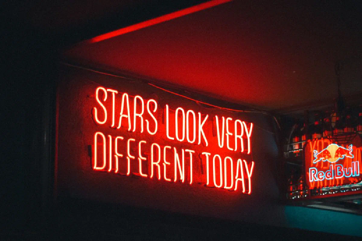 Red neon sign in a bar with the quote 'Stars look very different today'.