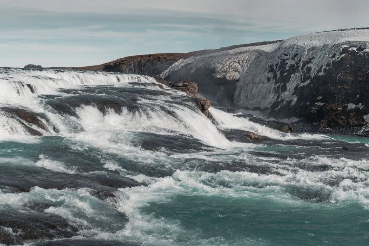 Discover the dramatic beauty of an Icelandic waterfall cascading powerfully over icy rocks.