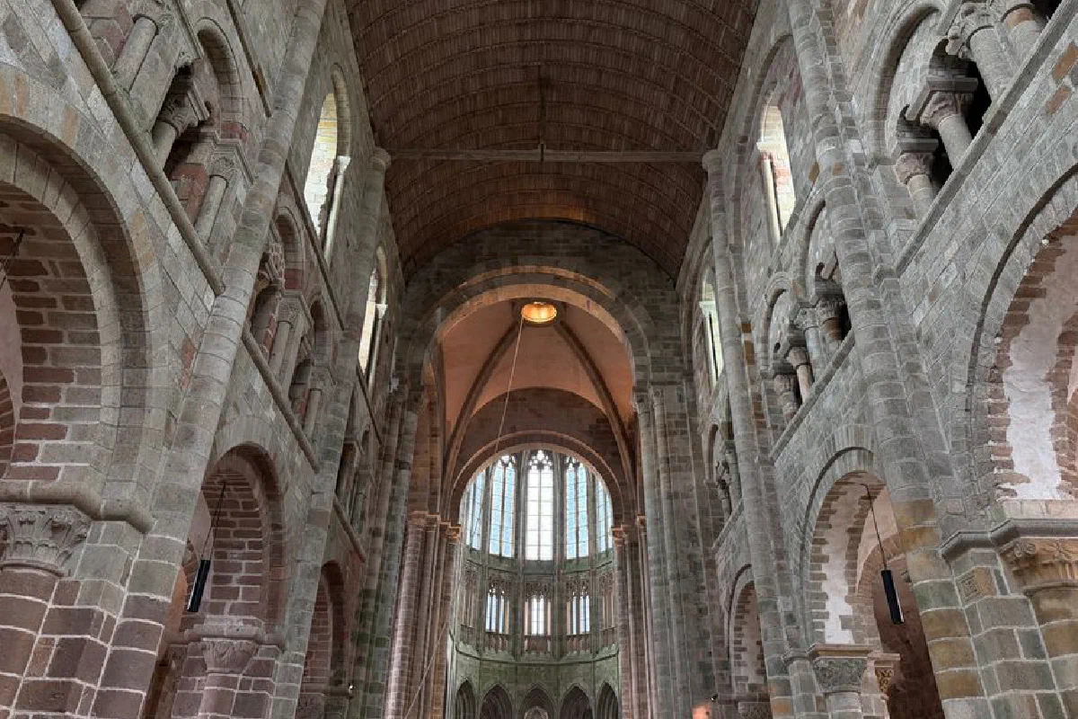 Majestic interior view of Mont Saint-Michel Abbey showcasing Gothic arches and stone architecture.