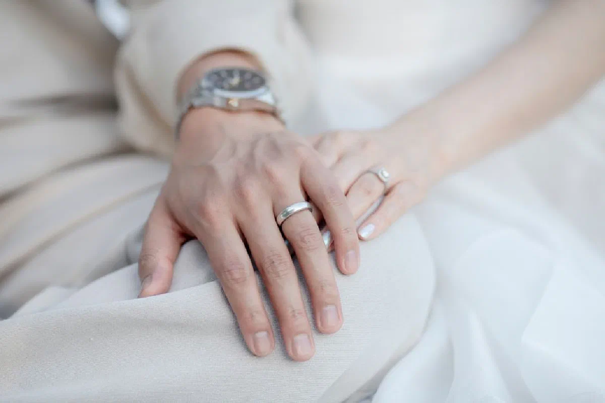 Intimate close-up of a couple's hands with wedding rings, symbolizing love and commitment.