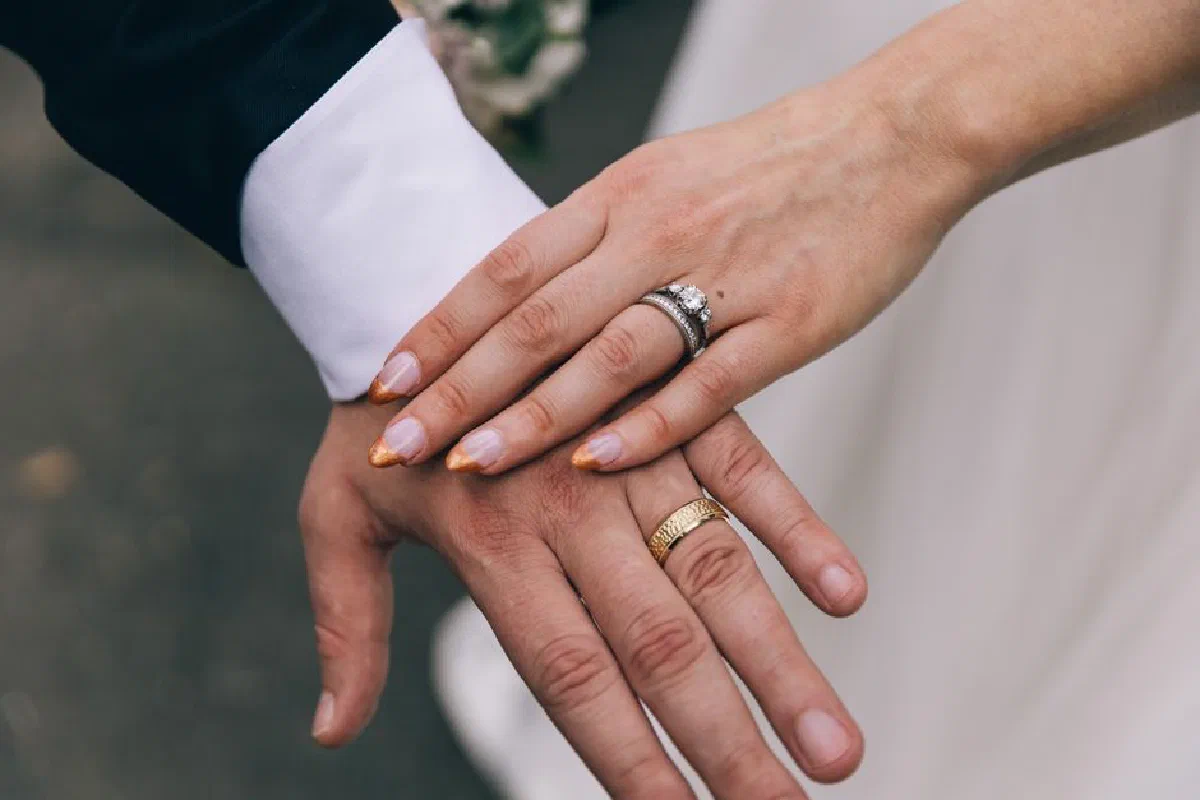 A close-up shot of a couple's hands with wedding rings, symbolizing love and marriage.