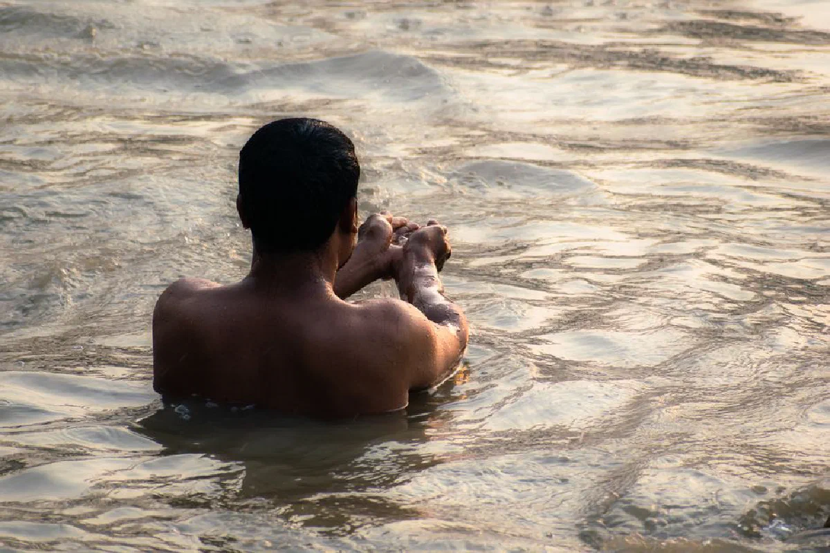 A man performs a spiritual morning ritual in the sacred Ganges River, Kolkata.