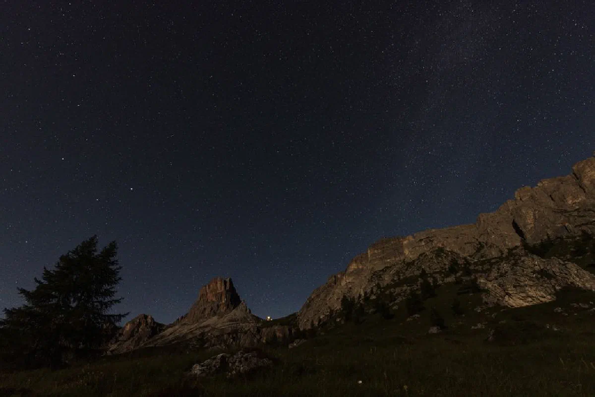 Stunning view of a starry sky over the rugged Dolomite mountains, perfect for travel and nature lovers.