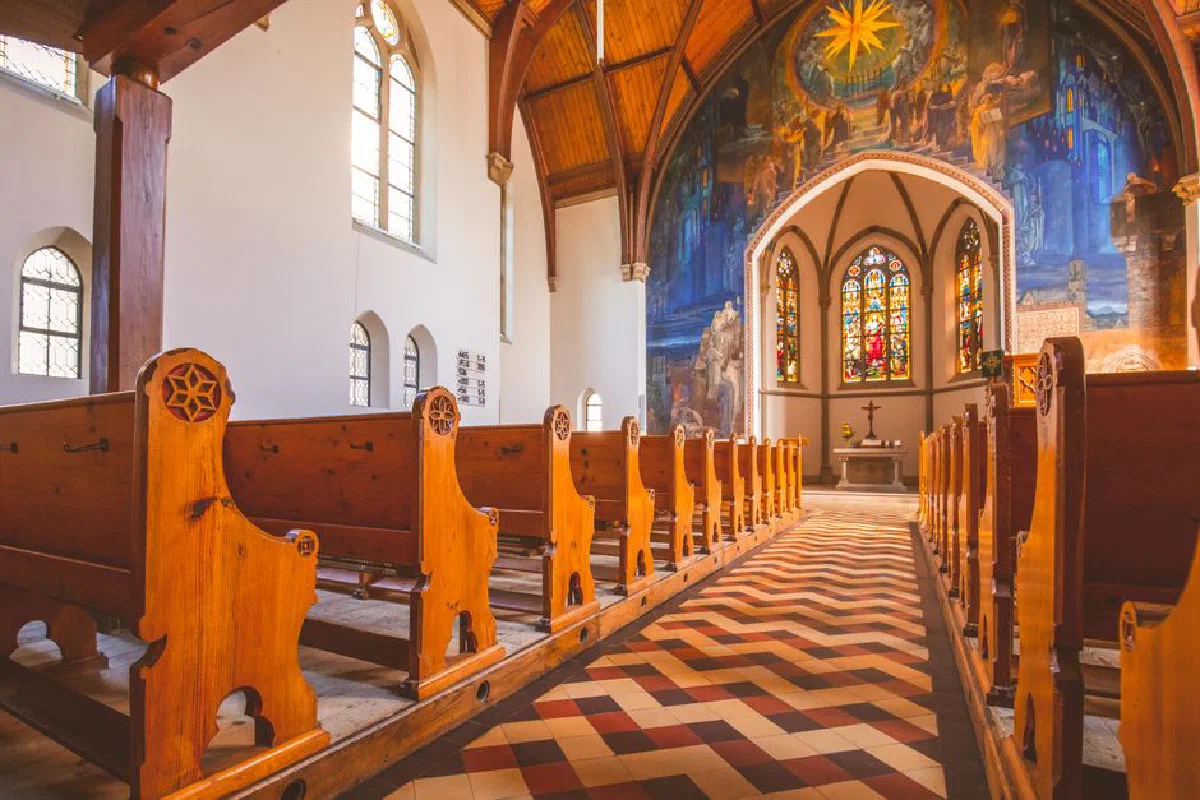 Explore the beautiful church interior featuring wooden pews, stained glass, and religious art.