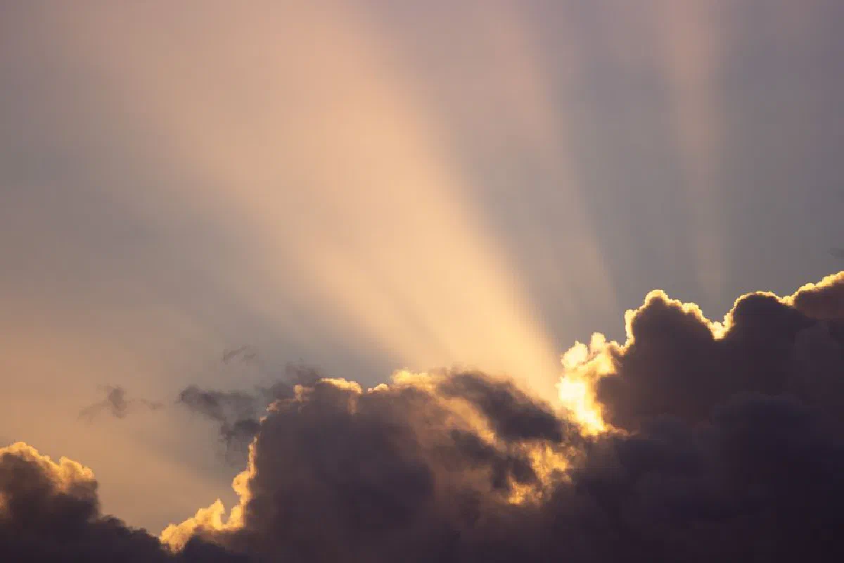 A stunning sunset scene with sunlight streaming through dramatic clouds.
