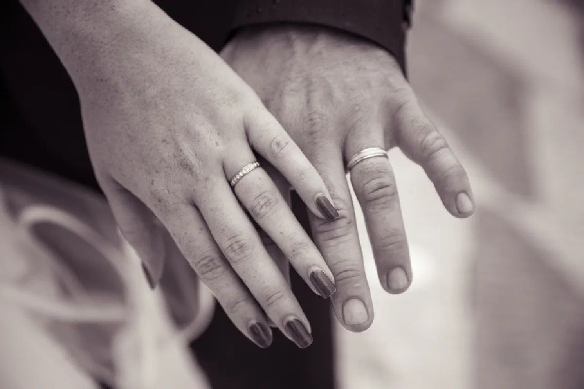 Close-up of hands with wedding rings symbolizing love and commitment.